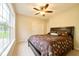 Comfortable bedroom with a large window, ceiling fan, and a bed with a decorative comforter at 7242 Blue Ridge Dr, Noblesville, IN 46062
