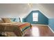 Attic bedroom featuring a unique architectural design, wood flooring, and cozy lighting at 7242 Blue Ridge Dr, Noblesville, IN 46062
