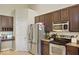 Well-equipped kitchen with stainless steel appliances, dark wood cabinets, and granite countertops at 7242 Blue Ridge Dr, Noblesville, IN 46062