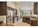 Modern kitchen with stainless steel appliances, dark wood cabinetry, and granite countertops at 7242 Blue Ridge Dr, Noblesville, IN 46062
