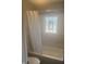 Bathroom with white marble tile, bathtub with shower, and glass block window at 732 W 700 N, Fortville, IN 46040