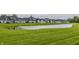 Backyard of homes with a tranquil pond, lush green grass and community space at 747 Tuxedo Dr, Westfield, IN 46074