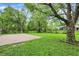 Expansive backyard showcasing a concrete patio, mature trees, and a well-maintained lawn, offering ample space at 7625 E 35Th St, Indianapolis, IN 46226