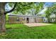 Spacious backyard featuring a stone house, concrete patio, and lush green lawn, perfect for outdoor enjoyment at 7625 E 35Th St, Indianapolis, IN 46226
