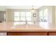 Close up of a white kitchen sink on a light countertop with a view of the yard through big windows at 808 Heartland Ln, Brownsburg, IN 46112