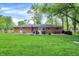 A view of the backyard featuring the brick house, manicured lawn and privacy fence at 820 S Eaglewood Dr, Zionsville, IN 46077