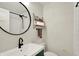 Bathroom featuring a modern sink, toilet, updated fixtures, and a decorative round mirror at 820 S Eaglewood Dr, Zionsville, IN 46077