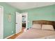 A bedroom with light green walls, wooden floors and view into a second bedroom at 820 S Eaglewood Dr, Zionsville, IN 46077