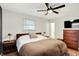 Bright bedroom with a large bed, wood furniture, and a ceiling fan at 820 S Eaglewood Dr, Zionsville, IN 46077