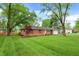 Well-manicured lawn highlights this charming single-story brick home with mature trees at 820 S Eaglewood Dr, Zionsville, IN 46077