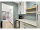 Hallway and kitchen view, showing white cabinets, shelves, and a small beverage fridge at 820 S Eaglewood Dr, Zionsville, IN 46077