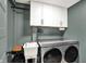 Laundry room features modern washer and dryer, storage cabinets, and functional sink at 820 S Eaglewood Dr, Zionsville, IN 46077