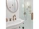 Elegant bathroom with a vintage-inspired sink, bronze fixtures, and tiled shower with glass door at 847 N Park Ave, Indianapolis, IN 46202