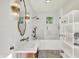 Bright bathroom with white tile, a glass enclosed shower, and brass fixtures at 847 N Park Ave, Indianapolis, IN 46202
