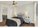 Cozy bedroom with hardwood floors, a ceiling fan, and decorative bedside lamps at 847 N Park Ave, Indianapolis, IN 46202