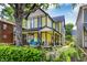 Charming yellow two-story home with inviting front porch and beautiful landscaping at 847 N Park Ave, Indianapolis, IN 46202