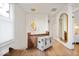 Well-lit hallway with hardwood floors, a decorative mirror, and stylish pendant lighting at 847 N Park Ave, Indianapolis, IN 46202