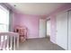 Pink bedroom with carpet, a bright window, door to the hallway and a closet at 895 Geronimo Dr, Greenfield, IN 46140