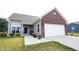Charming home with gray siding, brick accents, manicured lawn, and an attached two-car garage at 895 Geronimo Dr, Greenfield, IN 46140