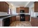 Galley kitchen features dark countertops and backsplash, and dark wooden cabinetry at 895 Geronimo Dr, Greenfield, IN 46140