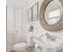 Bathroom features a pedestal sink, round mirror, and classic fixtures at 914 N College Ave, Indianapolis, IN 46202