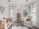 Bright Bedroom featuring a white crib, cozy rocking chair, and stylish decor at 914 N College Ave, Indianapolis, IN 46202