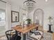 Elegant dining room featuring a modern chandelier, light hardwood floors, and large wooden table with seating at 914 N College Ave, Indianapolis, IN 46202