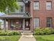 Inviting brick home entrance with covered porch, tasteful decor, seating, and manicured front garden at 914 N College Ave, Indianapolis, IN 46202