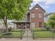 Charming brick home featuring a secure wrought iron fence and inviting front porch at 914 N College Ave, Indianapolis, IN 46202