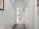 Bright hallway leads to a bathroom, featuring white paneled doors at 914 N College Ave, Indianapolis, IN 46202