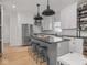 Modern kitchen with white cabinets, subway tile, stainless appliances, and a central island with seating at 914 N College Ave, Indianapolis, IN 46202