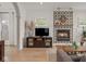 Open-concept living room with entertainment center featuring stylish decor, a cozy fireplace, and wood floors at 914 N College Ave, Indianapolis, IN 46202