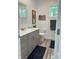 Cozy bathroom featuring gray vanity with white countertop, complemented by a wooden flag and a mirror at 951 N Maiellen Dr, Greenfield, IN 46140
