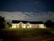 Inviting brick home at night with landscape lighting and a beautifully maintained lawn at 951 N Maiellen Dr, Greenfield, IN 46140