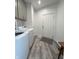 Well-lit laundry room featuring gray cabinets, wood-look floors, and a modern washer and dryer at 951 N Maiellen Dr, Greenfield, IN 46140