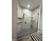 Contemporary bathroom shower featuring gray and white marble, built-in shelving, and glass door at 951 N Maiellen Dr, Greenfield, IN 46140