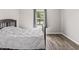 Bright bedroom with wood-look flooring, a large window, and a comfortable bed at 9560 W Campfire Dr, Pendleton, IN 46064