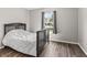 Inviting bedroom with wood-look flooring, a large window, and a comfortable bed at 9560 W Campfire Dr, Pendleton, IN 46064