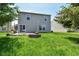 Exterior of home features an expansive backyard with a firepit and lush green grass at 9676 W Constellation Dr, Pendleton, IN 46064