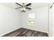 This bedroom features wood-look floors, a ceiling fan, neutral paint, and a window at 9676 W Constellation Dr, Pendleton, IN 46064