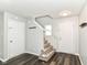 Bright entryway with wood-look floors, white doors, carpeted stairs, and a coat rack at 9676 W Constellation Dr, Pendleton, IN 46064