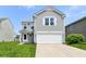Inviting two-story home featuring a two-car garage, neat landscaping, and light gray siding at 9676 W Constellation Dr, Pendleton, IN 46064