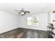 Light and airy living room with wood-look floors, ceiling fan, and large windows offering plenty of natural light at 9676 W Constellation Dr, Pendleton, IN 46064