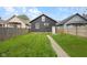 A spacious, grassy backyard featuring a stone walkway and a privacy fence, ideal for outdoor entertaining at 1016 Churchman Ave, Indianapolis, IN 46203