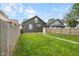 View of the backyard with a grass lawn, wooden fence, and a stone path leading to the rear entrance at 1016 Churchman Ave, Indianapolis, IN 46203