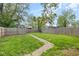 A large backyard featuring a wooden fence and stone walkway, providing a private and serene outdoor space at 1016 Churchman Ave, Indianapolis, IN 46203