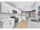 Modern kitchen with white cabinets, stainless steel appliances, and breakfast bar at 1016 Churchman Ave, Indianapolis, IN 46203