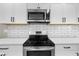 Updated kitchen featuring stainless steel stove, microwave and white subway tile at 1016 Churchman Ave, Indianapolis, IN 46203
