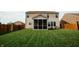 Manicured backyard features lush green grass, a privacy fence, and a screened in patio at 10447 Pintail Ln, Indianapolis, IN 46239