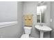 Cozy bathroom with white fixtures, a pedestal sink, and a window at 10447 Pintail Ln, Indianapolis, IN 46239